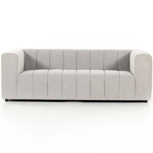 Sofa tapicerowana o spokojnej linii z delikatnym akcentem w odcieniu bieli