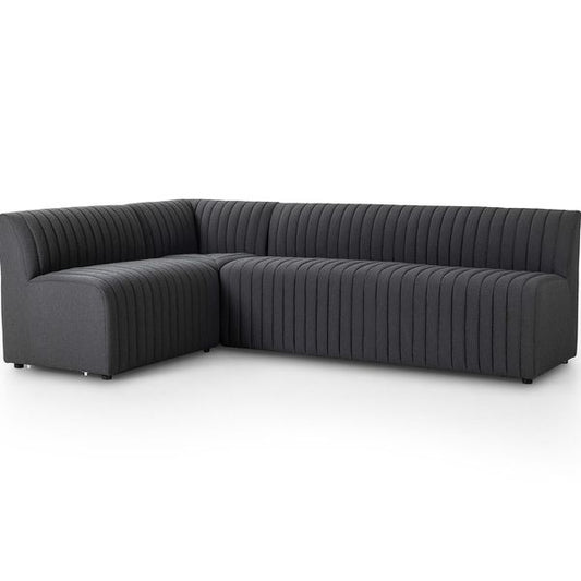 Sofa narozna o wyrazistej formie z delikatnym akcentem w odcieniu czerni