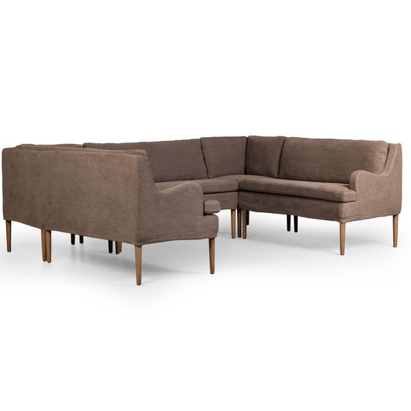 Sofa narozna o wyrazistej formie z oszczednym detalem w odcieniu brazu